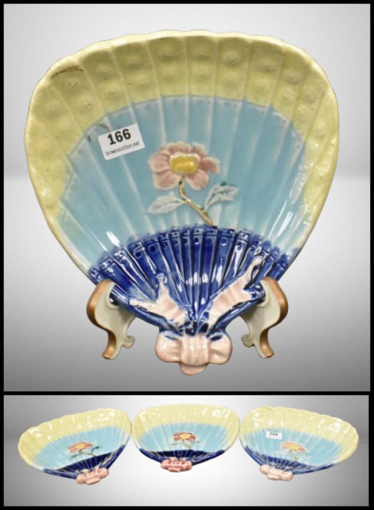 (3) Majolica fan and bow-shaped floral nappy trays; 6"d at widest part and 6.5"l. Please use: (3) Majolica fan and bow-shaped floral nappy trays; 6"d at widest part and 6.5"l. Please use pictures as part of the description. Brown Auction attempts to call any flaw that can affect the value of e