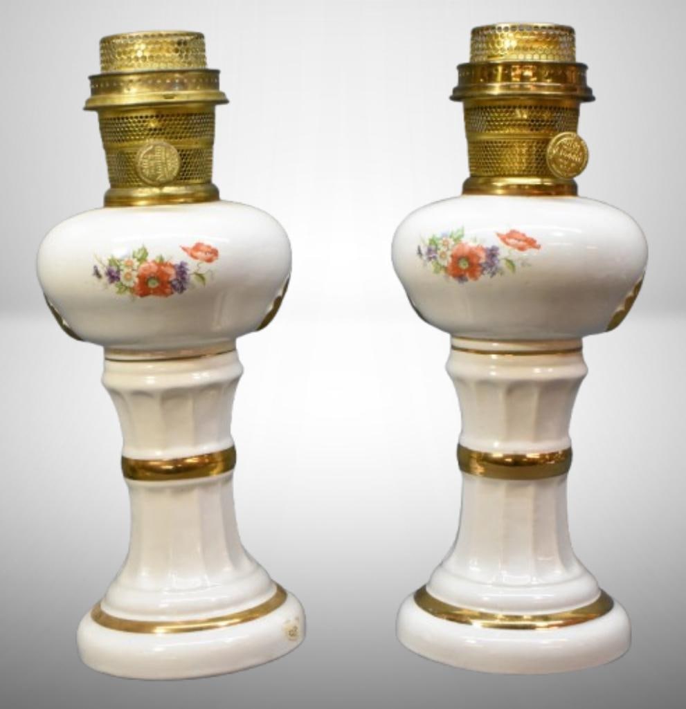 (2) Aladdin-style porcelain lamps with applied floral decor and gold gilting: (2) Aladdin-style porcelain lamps with applied floral decor and gold gilting; 10.5" to top of font. Please use pictures as part of the description. Brown Auction attempts to call any flaw that can aff