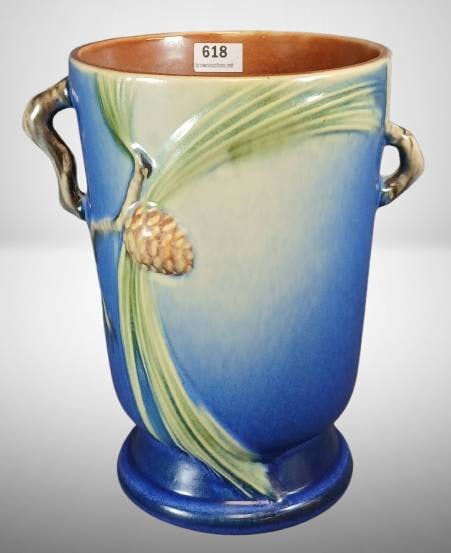 Roseville Pine Cone 704-7" Vase, Blue: Roseville Pottery Pine Cone 704-7 vase in blue, featuring dual handles and raised pine cone motif. No chips, cracks, or repairs. The base is unmarked, with characteristic Roseville glaze and detailing