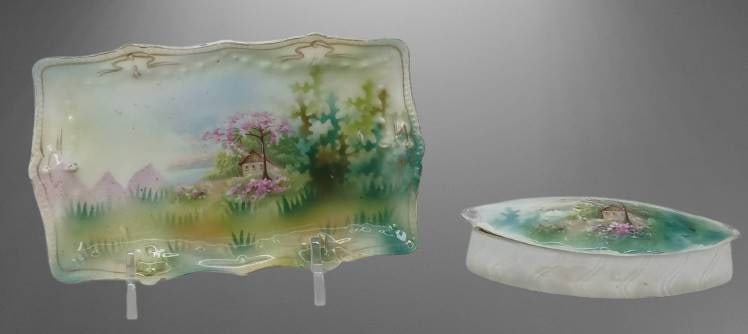 RP S Prussia Vanity Tray and Pin Box ?: Hand-painted RP S Prussia porcelain tray and box featuring a scenic design of a house surrounded by pink trees and greenery. Both pieces exhibit a gold-accented design. The tray measures approximately