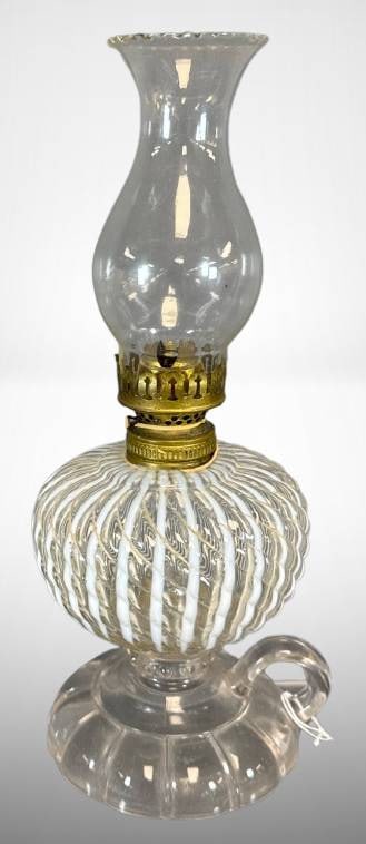 Clear Opalescent Glass Sheldon Swirl Kerosene Hand Lamp: Clear opalescent glass kerosene lamp with a sheldon swirl pattern. Features a brass burner crown and a glass chimney. Includes a handle on the base for portability. Condition appears consistent with a