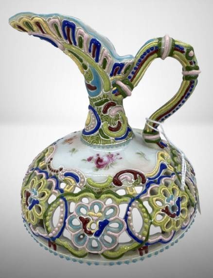 Hand-Painted Porcelain Decorative Ewer: Hand-painted porcelain 4.5" squatty ewer with ornate multi-colored floral and scroll designs. Features a fluted neck and curvilinear handle. The base is unmarked. Dimensions are specified using the in