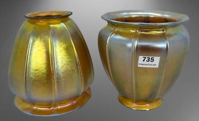Steuben Gold Aurene Art Glass Lamp Shades: Steuben gold aurene art glass lamp shades. Both display decorative iridescent tones. Each shade has a chipped base, one with a larger chip and the other with a smaller chip. Dimensions are visible thr