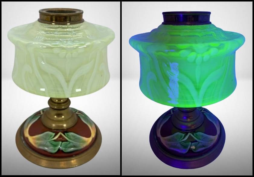 Vaseline Glass Lamp with Floral Base: Table lamp featuring a Vaseline glass body that fluoresces under UV light. Body also features an opalescent floral design. Decorated pottery base with a colorful floral and leaf design on a red backdr