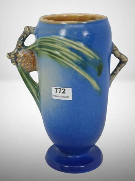 Roseville Pine Cone 748-6" Vase, Blue: Roseville Pottery Pine Cone vase, featuring a blue glaze with raised pine cone and branch detailing. Marked with "Roseville" and the mold number on the base. Overall condition appears good with light 