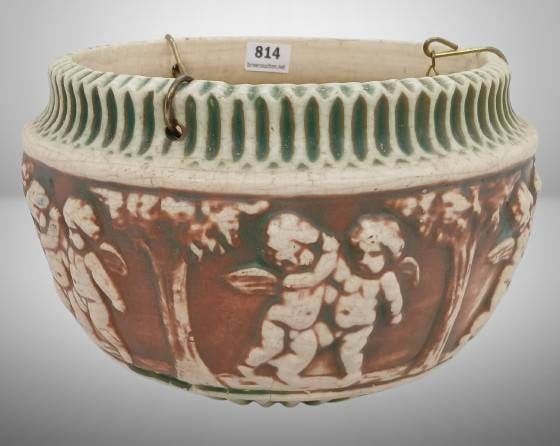 Roseville Donatello 327-6" Hanging Basket: Roseville Donatello 327-6" hanging basket featuring cherub designs and a ribbed rim with original hanging chains. Marked with the Roseville stamp on the interior. Small crack near the bottom edge and 
