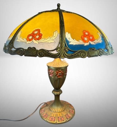 Reverse Painted Glass Table Lamp With Floral Scenes: Reverse painted glass table lamp featuring 6 panels with floral scenes and a metal base decorated with floral motifs. Dual bulb sockets with functional wiring. Base includes a green felt bottom. Attra