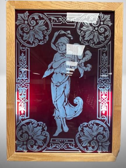 Etched Glass Winter Theme Panel in Oak Frame: Etched glass panel depicting a figure titled 'Winter,' surrounded by decorative floral motifs. Encased in an oak wood frame. The overall dimensions are 28.5" x 21". Features chain hardware for hanging