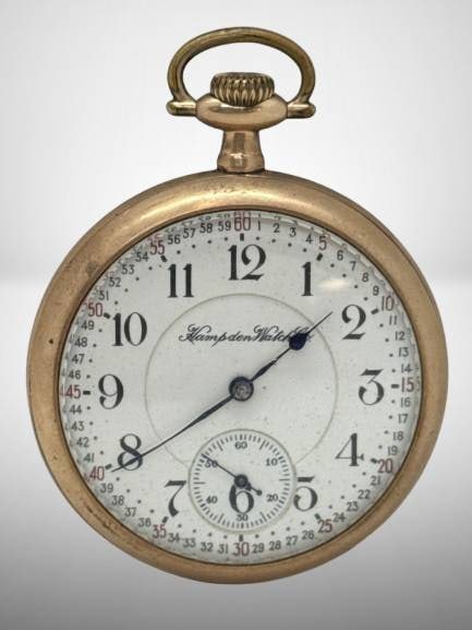 Hampden Watch Co. 21-Jewel Gold-Filled Pocket Watch: Hampden Watch Co. pocket watch with 21 jewels, featuring a gold-filled case and engraved markings. Noted as working but requires some mechanical upkeep. Serial number 105 visible on movement. 20-year