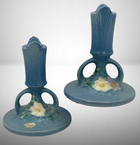 Roseville Cosmos 1137-4.5" Candle Sticks, Blue: Roseville Pottery Cosmos 1137-4.5" candle sticks in the blue glaze. Features raised floral design, and a Roseville sticker present on one. No chips, cracks or repairs. In-house shipping available.