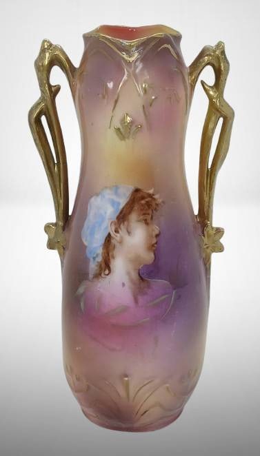 Royal Vienna Germany Peasant Girl Vase: Mrkd. Royal Vienna Germany 7.25"h vase featuring a handpainted portrait of a peasant girl. Adorned with gold-tone handles, decorated in soft pastel hues. No chips, cracks, or repairs. In-house shippin