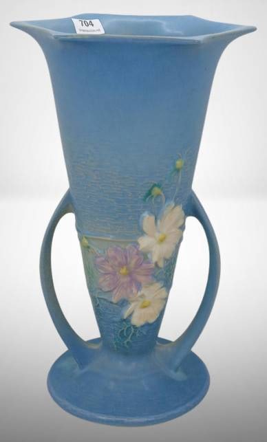 Roseville Cosmos 954-10" Blue Vase: This Roseville Cosmos 954-10" vase features a blue glaze adorned with a floral motif. It is in excellent condition with no chips, cracks, or repairs. A charming example of Roseville pottery craftsmans