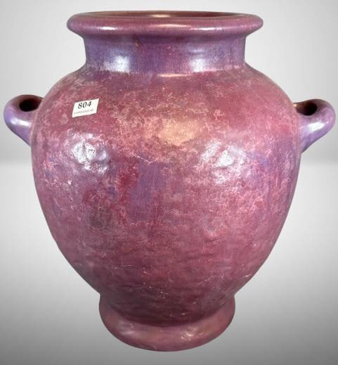 Fulper Pottery Vase with Glaze Flake: This Fulper Pottery 12"h vase showcases a rich purple glaze and features dual handles. A large glaze flake is present. The base is marked with the Fulper stamp, affirming its provenance. In-house ship
