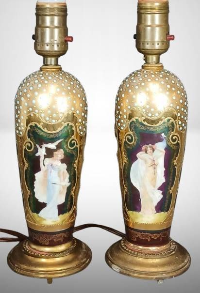 (2) Prussia Figural Portrait Lamps?: This pair of Prussia figural portrait lamp vases features applied turquoise beading and vibrant portrait scenes. One vase shows a small hit to the gold gilding. A stunning display of craftsmanship and