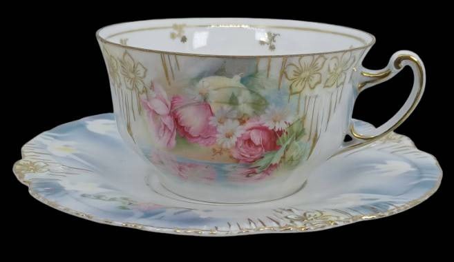 RS Prussia Icicle Mold Floral Cup and Saucer: Featuring a delicate floral motif, this RS Prussia Icicle Mold cup and saucer set displays Reflecting Poppies and Daisies pattern complemented by gilded highlights. Maintained in pristine condition wi
