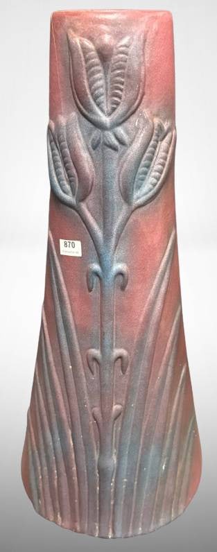 Van Briggle Art Nouveau Yucca Pottery Vase: This is a Van Briggle Art Nouveau Yucca matte glaze pottery vase, standing at 17"? tall. Displaying a detailed botanical motif, it has a matte mulberry finish. A pair of 3-inch cracks are visible on t