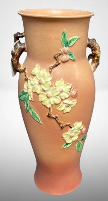 Roseville Apple Blossom 18-Inch Vase: This Roseville Apple Blossom 393-18" floor vase is a large, pink ceramic piece featuring raised floral motifs with branch-style handles. It exhibits a notable chip on the underside base. Roseville pot