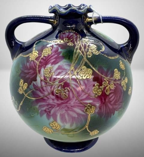 Unm. Nippon Bulbous Vase with Floral Design: This early bulbous 6" vase, attributed to Nippon craftsmanship, features striking hand-painted floral motifs accented with intricate gold embellishments. The cobalt ruffled top and dual handles add to