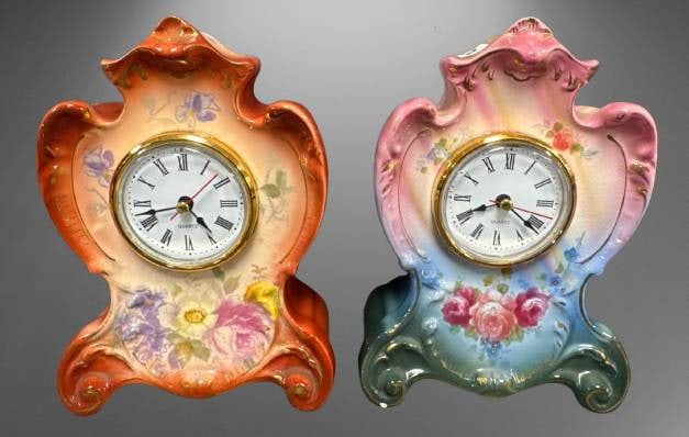 (2) Royal Bonn Germany Agate Mantel Clocks: This lot features (2) porcelain 7"h mantel clocks marked ??Royal Bonn Germany, Agate.' Each clock is adorned with floral motifs. Please note the pink clock has a small chip on the base and a couple of