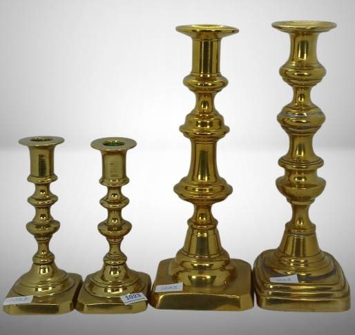 (2) Pr. Brass Candlesticks: (4) Brass candlesticks in two sizes, 6" and 9" tall, featuring pairs of matching pieces. Crafted from polished brass with some signs of wear and tarnish on bases and candle holders. In-house shipping