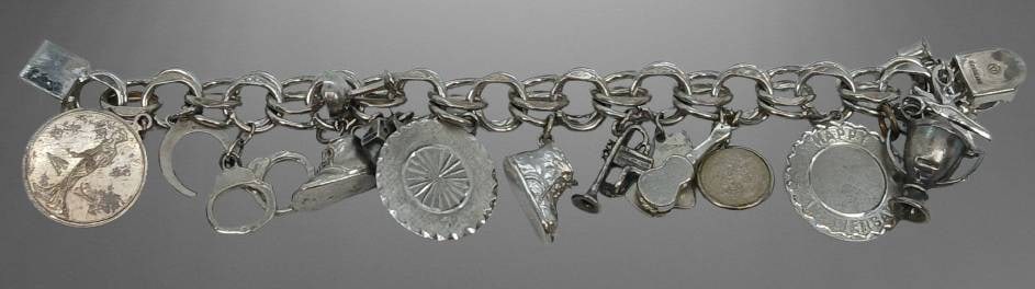 Sterling Silver Charm Bracelet with Charms: This sterling silver charm bracelet features multiple charms, including miniature objects like a coin, scissors, a shoe, and others. Stamped Sterling on the clasp and weighing approximately 83.27 gram