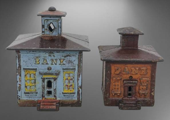 Cast Iron Bank Buildings: This lot includes a pair of cast iron bank buildings featuring cupolas and what appears to be their original paint. The detailed facades and coloration add to their charm. Both pieces show age-consist