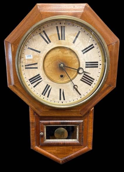 Octagonal Wall Clock With Key and Pendulum: This octagonal wall clock features Roman numerals on its aged clock face, encased in wood with brass accents. It includes a pendulum visible through a lower glass door, and a winding key for operation