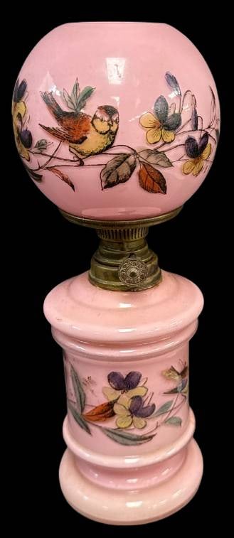 Miniature Pink Oil Lamp with Bird Design: This miniature pink oil lamp features a delicately handpainted bird and floral design on both the globe and base. The base of the globe has a small chip, and the chimney is missing. Spar Brenner burne