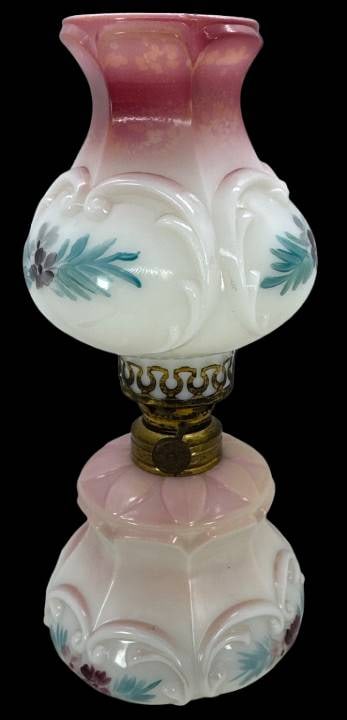 Miniature Handpainted Oil Lamp: Charming miniature oil lamp featuring a pink and opal cased glass base and shade with painted floral accents. Shade has small chips on the top and bottom rims, as shown in pictures. Includes a brass b