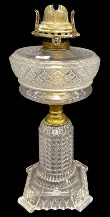 Early 20th-Century Glass Oil Lamp: This early 20th-century glass oil lamp features a Thousand Eye base and a Beaded Lattice font. A true example of handcrafted lighting, it reflects a sturdy presence. Measures 12" tall and shows a smal