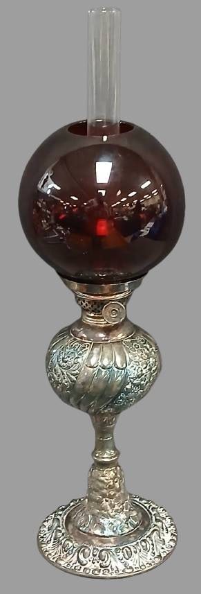 Simpson H. M. & Co. Quadruple Plate Lamp: This Simpson H. M. & Co. lamp features a quadruple-plated silver base with ornate floral and scroll detailing. Accompanied by a deep red glass globe and clear chimney, it showcases intricate craftsman