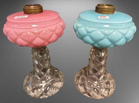 Quilt/Florette Kerosene Stand Lamps: This offering includes a pair of Quilt/Florette kerosene stand lamps with pink and blue fonts atop clear bases. Both lamps show no chips, cracks, or repairs. A charming addition to any mantel or colle