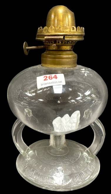 Ripley and Co. Double Handle Oil Lamp: This Ripley and Co. double handle oil lamp features a clear glass body with embossed details and a brass burner. It shows no chips, cracks, or repairs. A functional and collectible piece for any lamp