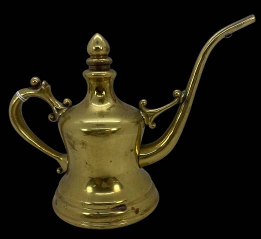 Brass Oil Lamp Filler by Buffalo Mfg Co: This brass oil lamp filler, crafted by the Buffalo Manufacturing Co., is a functional and historical artifact. Featuring an elegant spouted design and embossed markings on the base, this piece served 