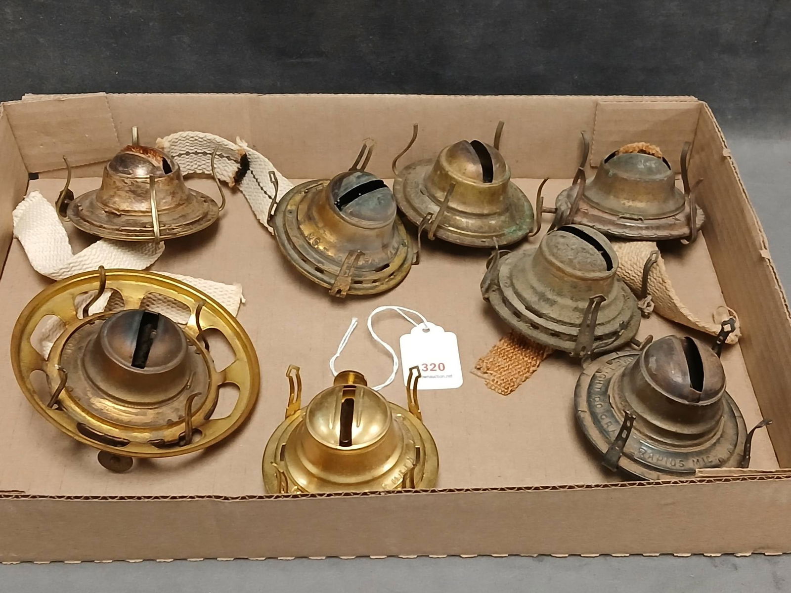 (8) Kerosene Lamp Burners: (8) Kerosene lamp burners, featuring various designs, markings, and patinas. Some are marked Queen Anne, White Flame Light Co., Eagleand others, showcasing intricate craftsmanship from different manuf
