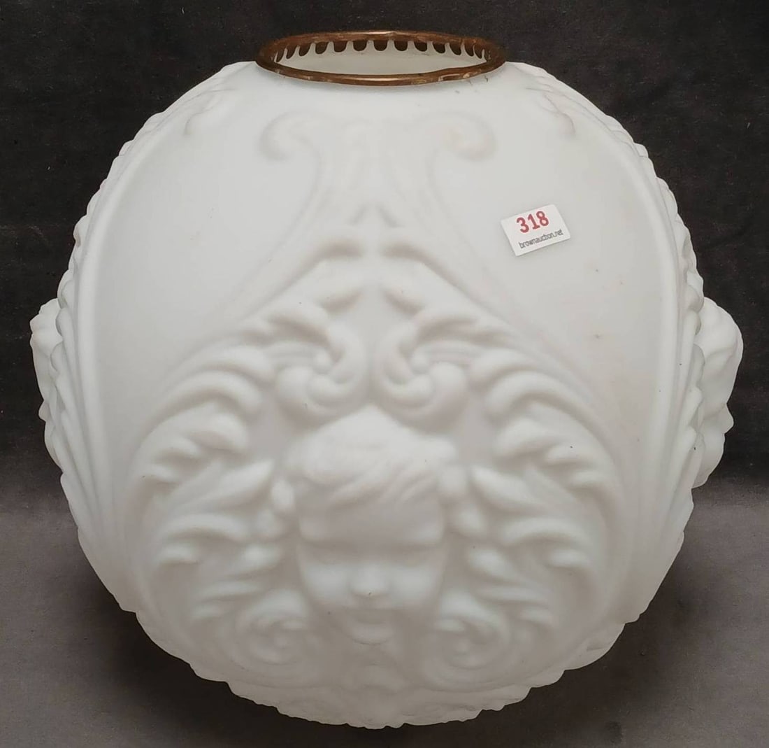 Victorian GWTW-Style Milk Glass Lamp Shade: This Victorian GWTW-style milk glass lamp shade features a delicate relief of a cherubic face surrounded by ornate scrollwork. Measuring approximately 10"d x 10" tall, the shade exhibits minor edge we