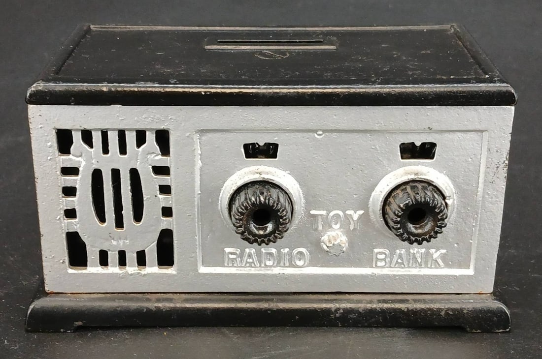 Vintage Metal Toy Radio Bank: Rare vintage metal toy bank designed to resemble a radio. Features a coin slot and rotary-style knobs with black and silver-tone detailing. Measures 5.5'? x 3'? x 3'?h. In-house shipping available.