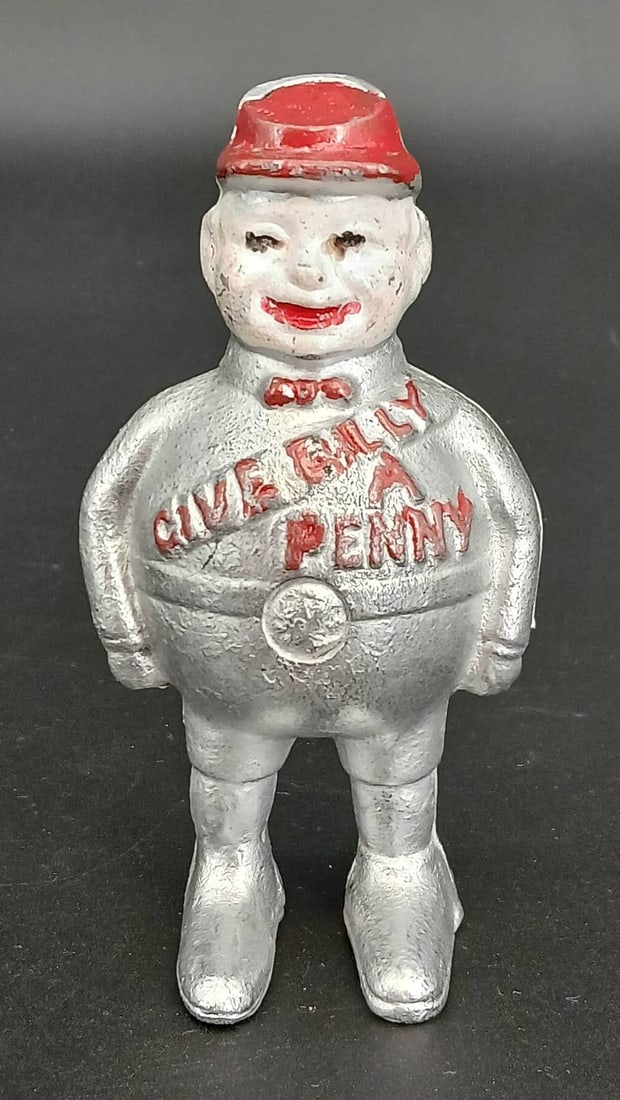 Cast Iron Novelty Bank: Cast Iron 'Give Billy a Penny' bank featuring a silver character design with red-painted accents and. Measures approximately 5" tall. Moderate wear with some paint loss noted. In-house shipping availa