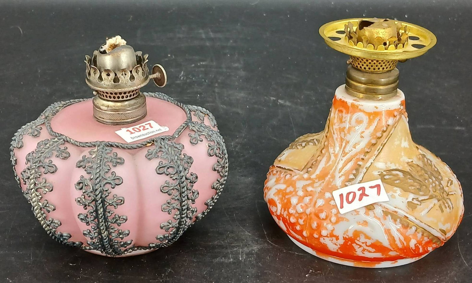 Decorative Glass Oil Lamps: Decorative glass oil lamps, one with pink and metal overlay marked 'The Meriden MFG Co', the other with orange and white design featuring a butterfly motif. Both include brass fittings. In-house shipp