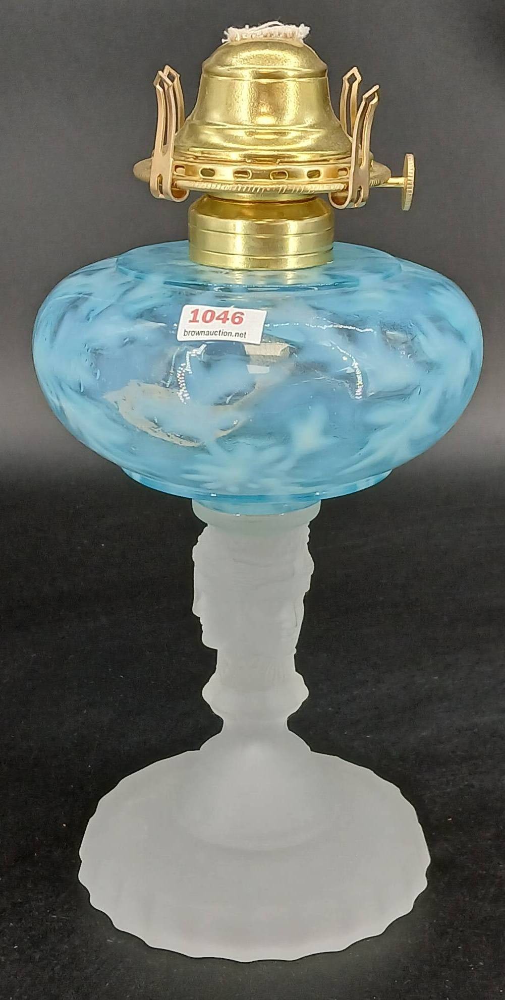 Blue Opalescent Oil Lamp With Frosted Three Faces Glass Base: Blue opalescent oil lamp featuring a frosted Three Faces glass base. Burner marked 'Queen Anne No. 2'. Overall in good condition with visible details. In-house shipping available.