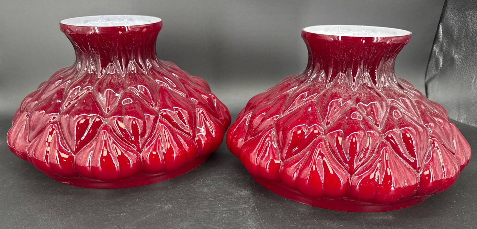 Pr. Aladdin Model 202 'Artichoke" Ruby Red Glass Lamp Shades - Reproductions: Pr. of Aladdin Model 202 'Artichoke" ruby red glass lamp shades, each with a 10" diameter base and 7"height. Shades are reproductions. Both are free of any chips, cracks, or repairs. In-house shipping