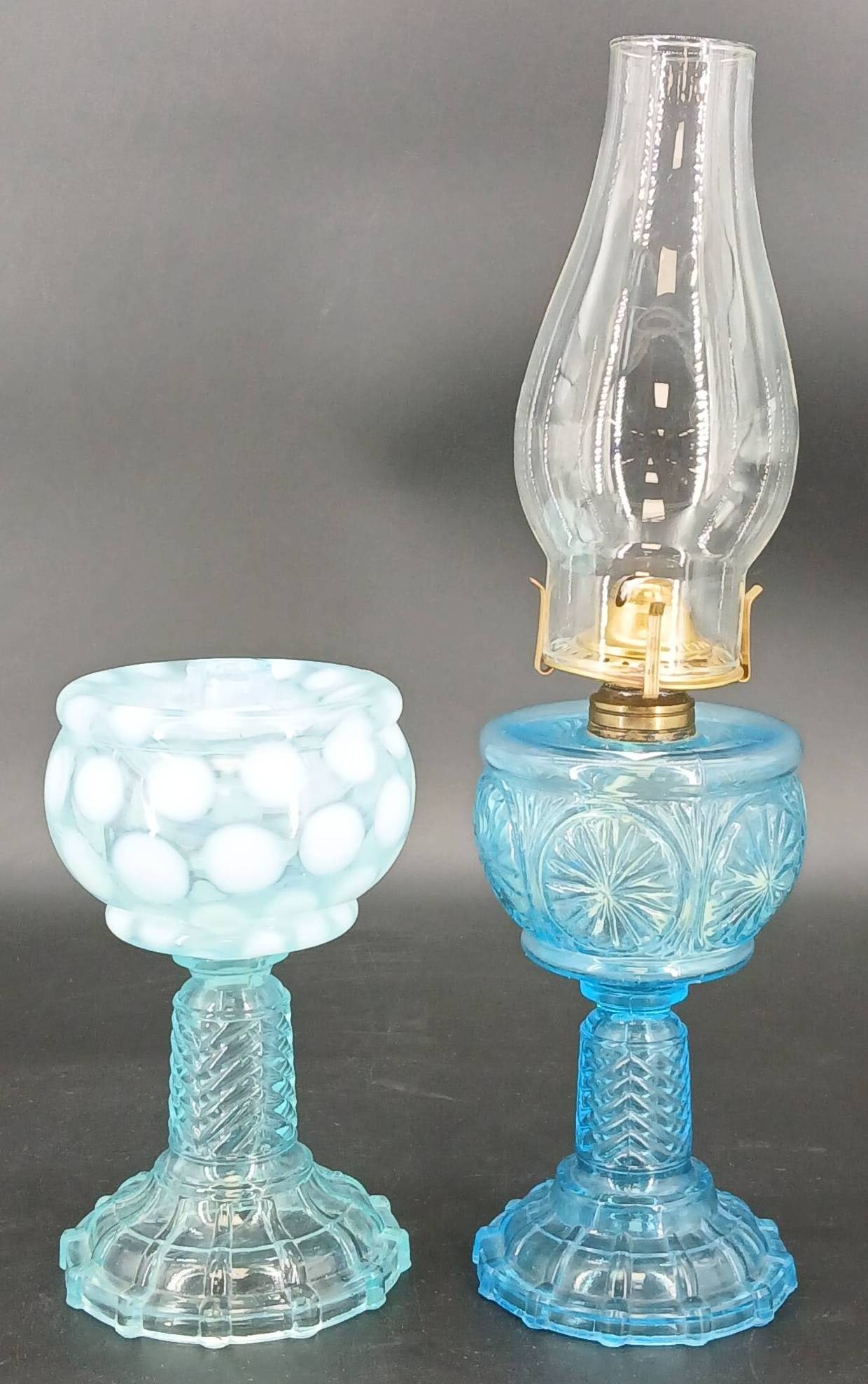 (2) Blue Glass Oil Lamps: (2) Glass oil lamps: blue opalescent Coin Dot, 8" tall (chips where burner fits over); blue Feather Duster, 9.5" to top of burner (small base chip), both on Chevron Ribbed base. In-house shipping avai