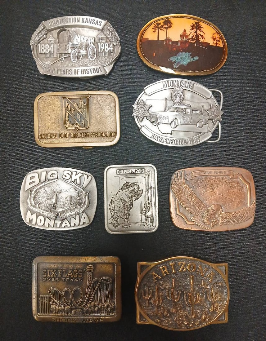 US Souvenir and Advertising Belt Buckles Collection (9): (9) US-themed souvenir belt buckles including commemorative pieces from Kansas, Montana, Six Flags Over Texas, Arizona, and others. Various makers, designs, and finishes in both brass and silver tone 