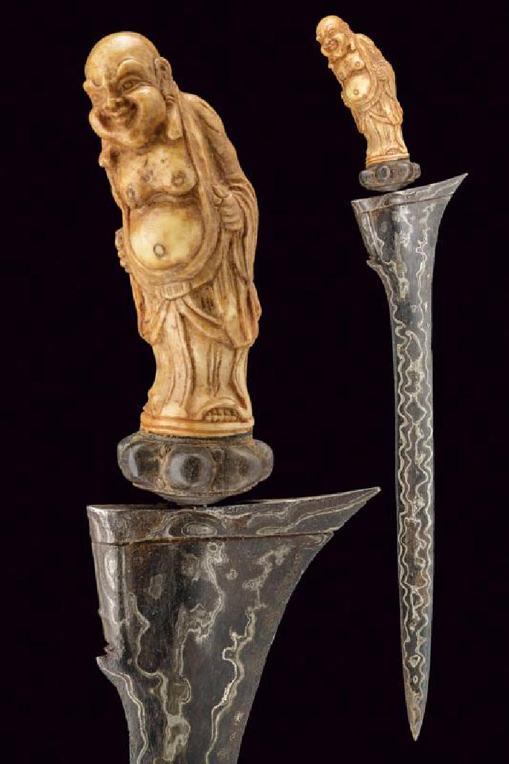 A kris, dating: , provenance: Bali, dating: ,: A kris, dating: , provenance: Bali, dating: , provenance: Bali, Antique, double-edged blade of a fine pamor, slightly chiselled at the base; bone grip carved with a Chinese man figure, wooden mendak.,