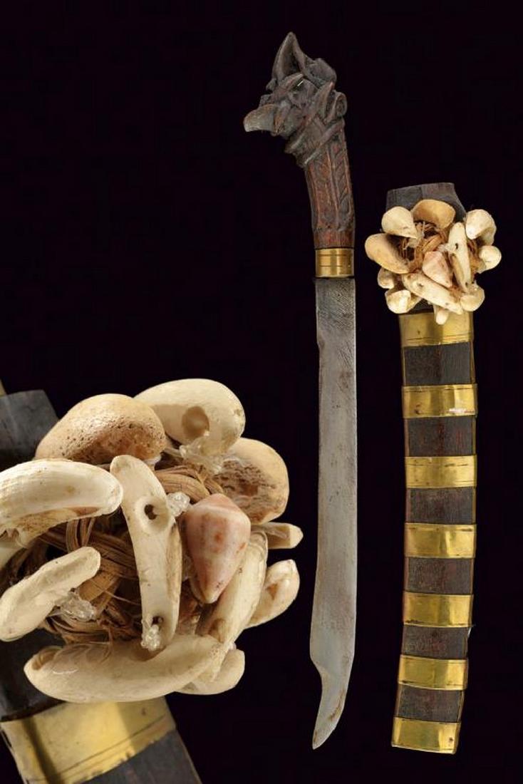 A rare small size Balato: dating: Late 19th Century provenance: Indonesia, Curved, iron, single-edged blade, cut on concave side and slightly hollowed tip. Brass ring-nut, wooden grip in one piece with big pommel, richly chise