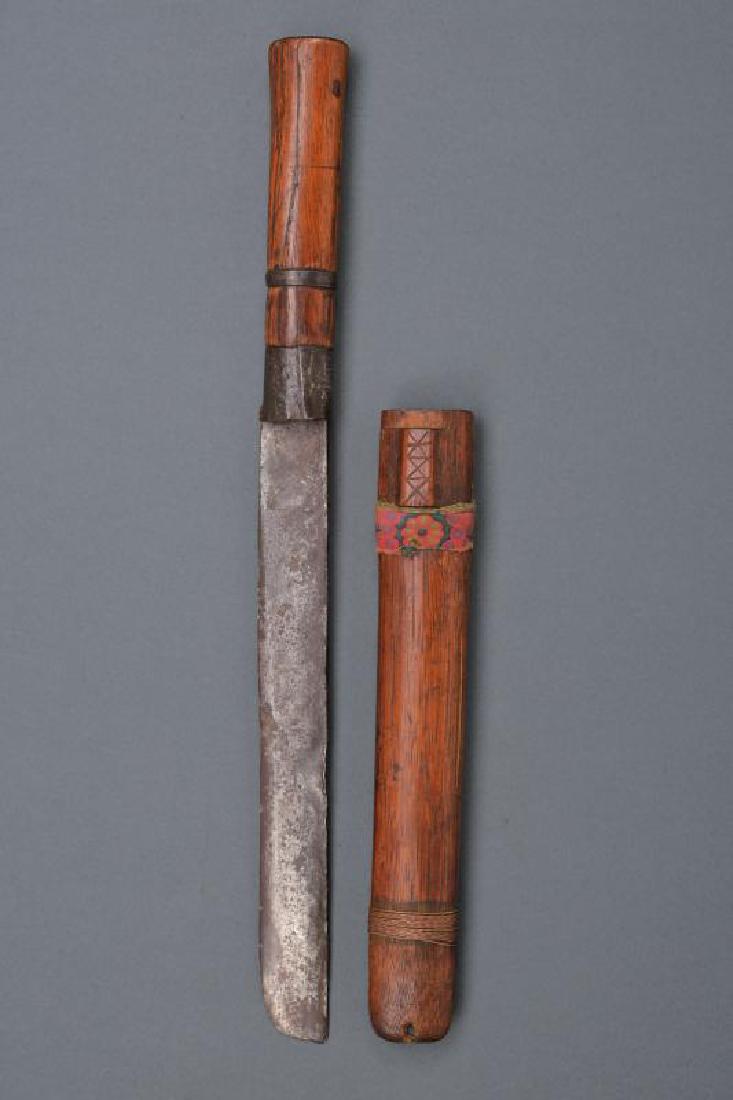 Machete: dating: 20th Century provenance: Indonesia, Strong, straight, single-edged blade with round tip; wooden grip with iron ring-nut and band. Wooden scabbard. length 47 cm.