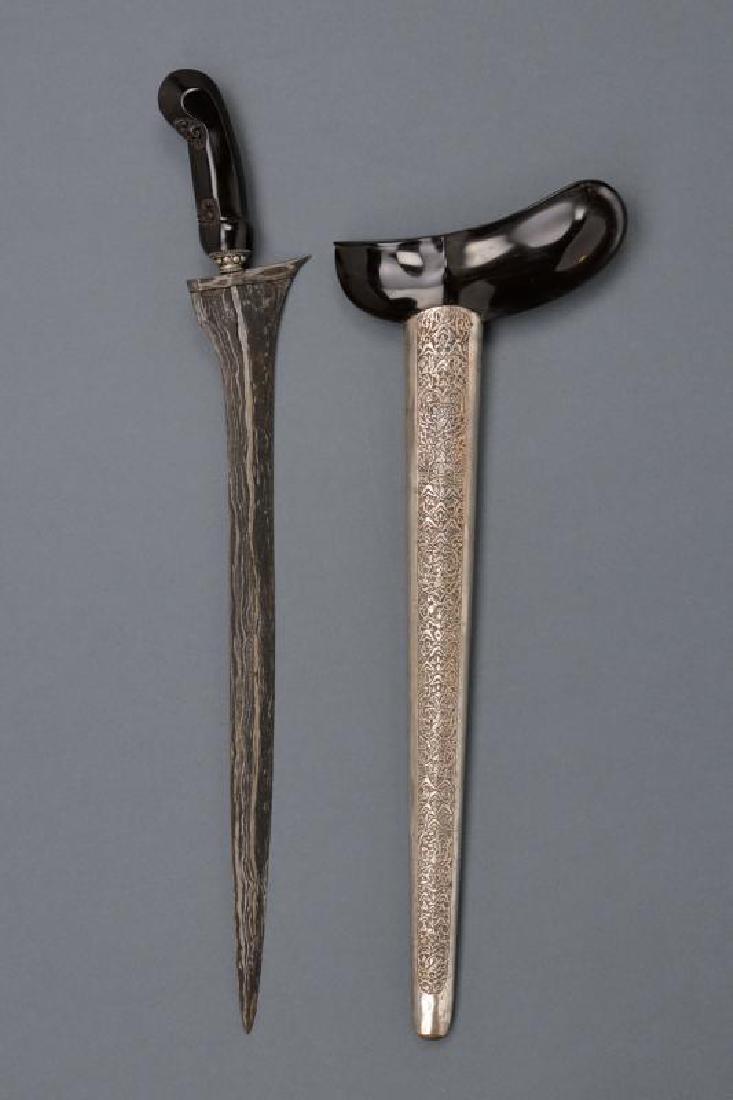 A kris: dating: 20th Century provenance: Giava, Straight, double-edged blade in pamor; ebony, embossed hilt, metal mendak decorated with spheres; ebony warangka (to be glued), white metal foil pendok richly e