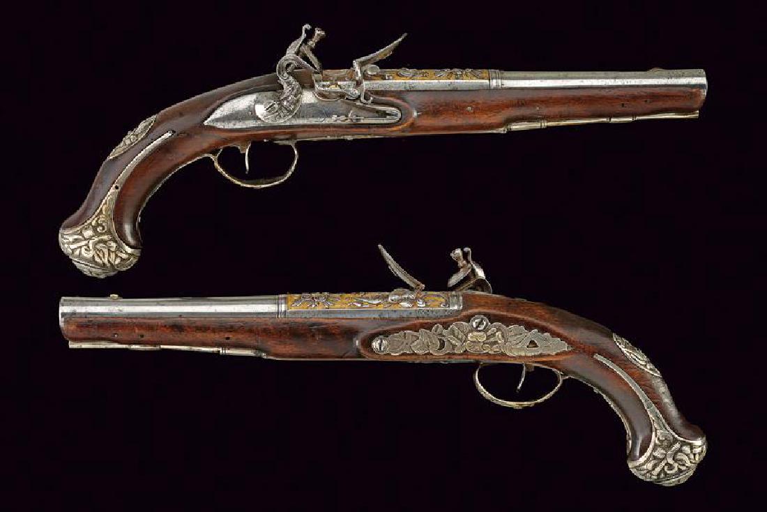 A beautiful pair of flintlock pistols: dating: circa 1800 provenance: Europe, Beautiful, smooth-bore, round, two-stage, 17 mm cal. barrels, first part chiselled with trophies under a crescent in a beamed crown, in high-relief and on a grai