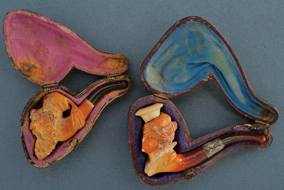 A lot of two cased pipes: dating: End of 19th beginning of 20th Century provenance: Europe, In sea foam, portraying a bearded man and a woman with a long knife. In original case. length 8 - 9 cm.
