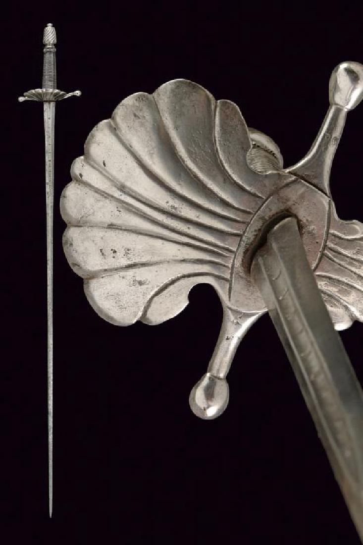 A composite sword: dating: 17th Century provenance: Italy, Straight, double-edged blade of lozenge section, first part with deep, central groove marked 'TOMASO AIALA'; iron hilt with double shell-guard portraying a big 